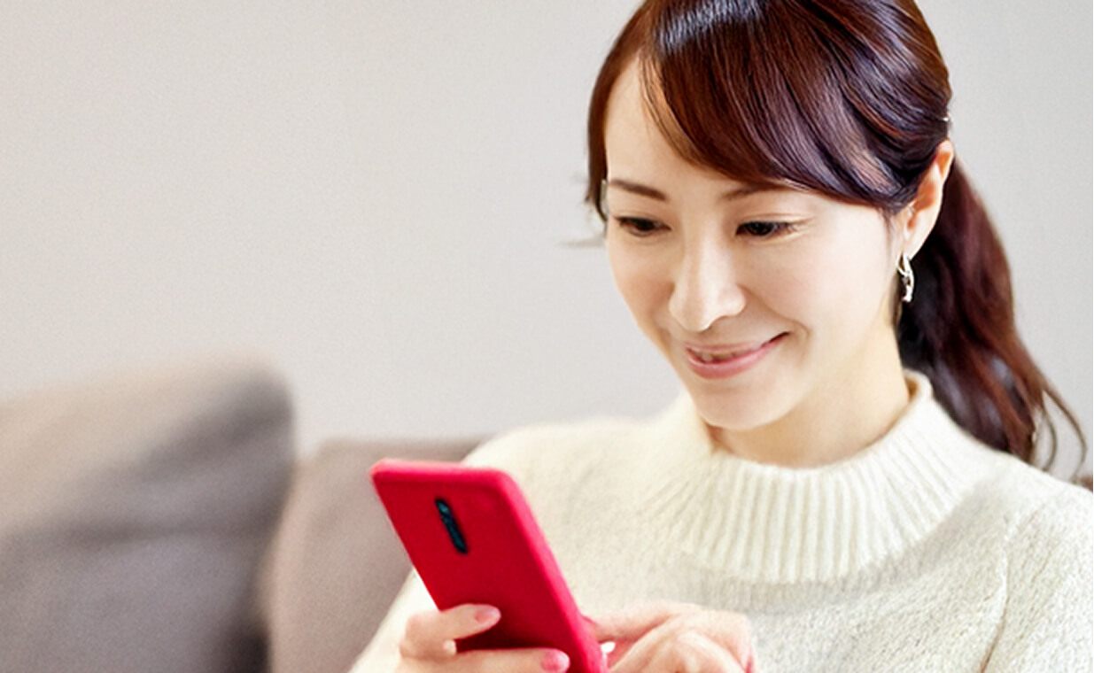30代くらいの女性がスマホで会員登録している様子