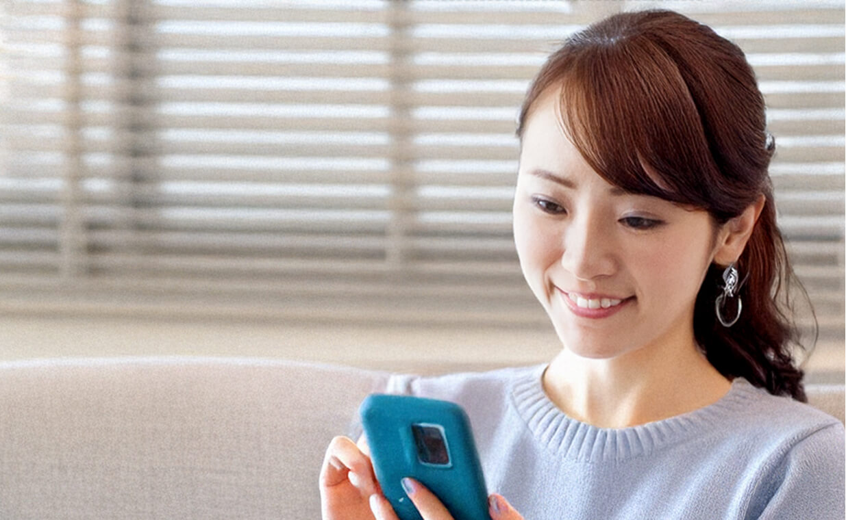 30代くらいの女性がスマホで会員登録している様子