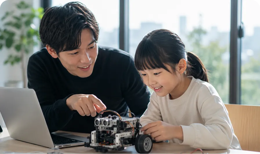 家庭教師と一緒にロボットを使ってプログラミング・テクノロジーを学ぶ子ども